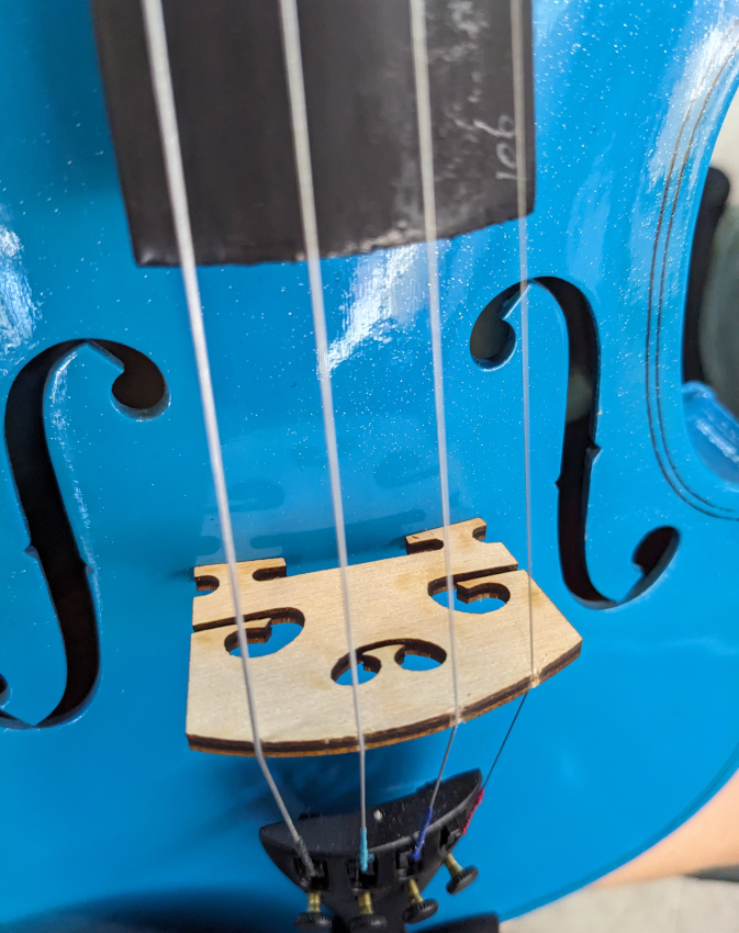 Laser cut bridge installed on the blue violin